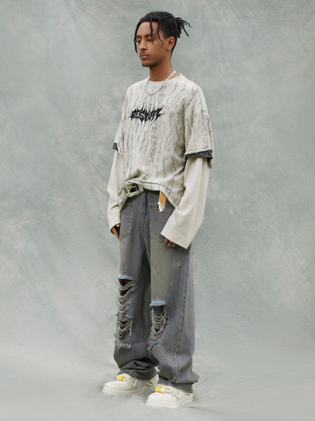 Model wearing TALISHKO's edgy faux two-piece distressed T-shirt layered over a long sleeve.