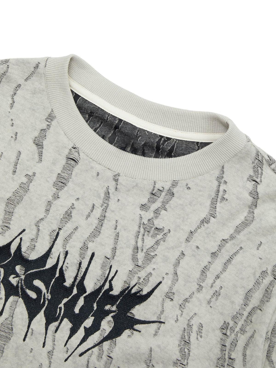A detailed view of TALISHKO's distressed faux two-piece T-shirt, highlighting textured patterns.