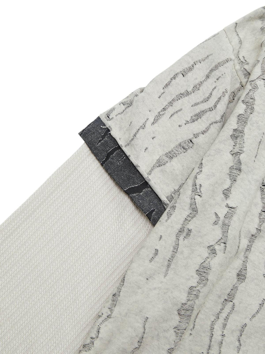 Texture and pattern showcased in TALISHKO's distressed woolen T-shirt with a layered design.