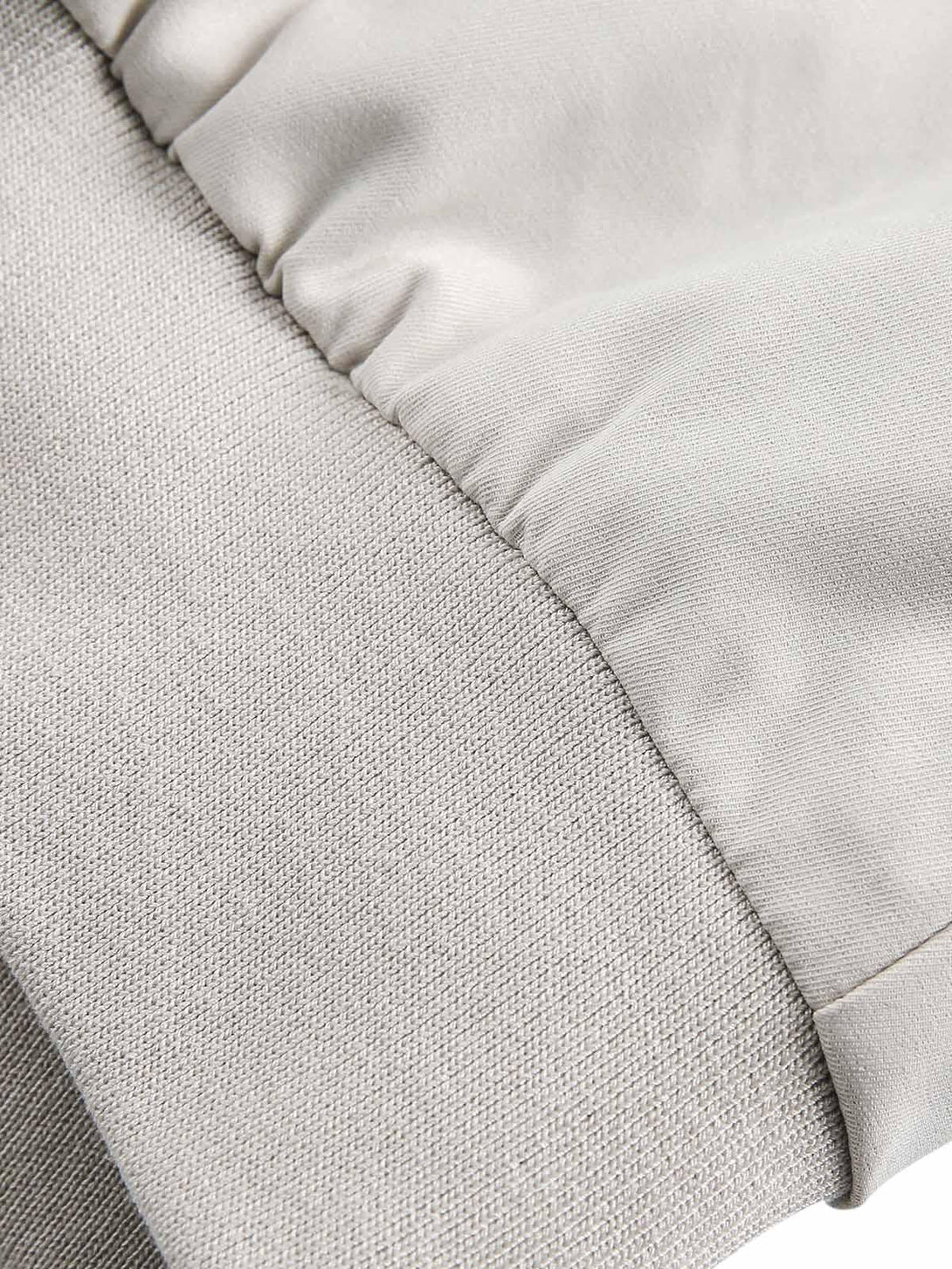 A tight crop highlighting TALISHKO's bomber jacket, showcasing the texture of the sleeve and cuff.