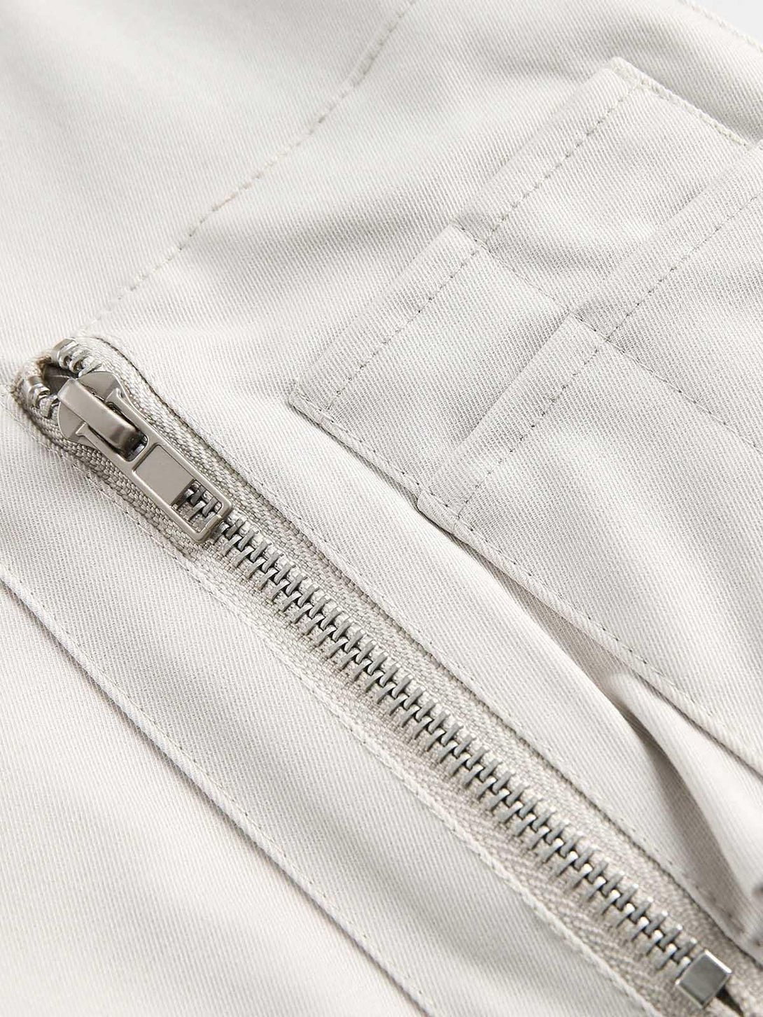 A detailed view of TALISHKO's bomber jacket, highlighting the zipper and pocket design.