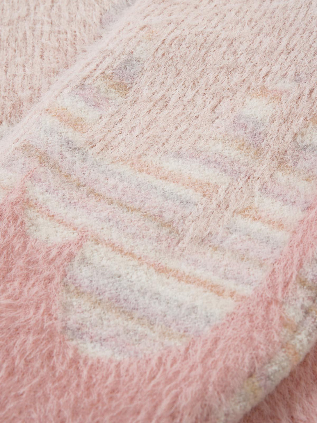 Texture and pattern showcased in TALISHKO's pink fuzzy sweater, highlighting its cozy design.