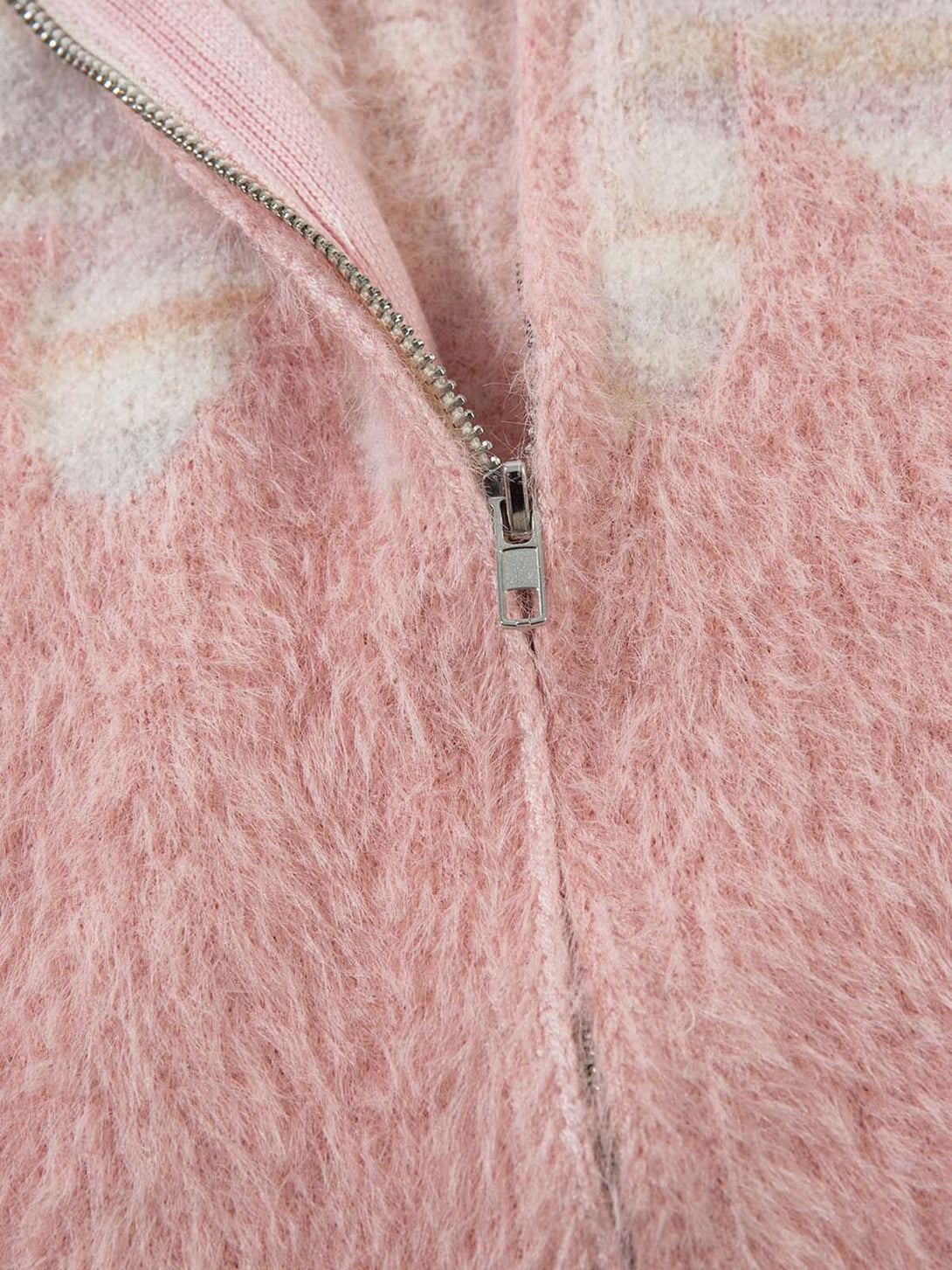 Focusing on the soft pink fuzziness and zipper detail of TALISHKO's sweater.