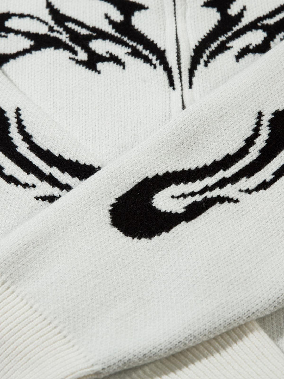 A detailed view of the flame pattern on a TALISHKO mock neck sweater, showcasing bold design.