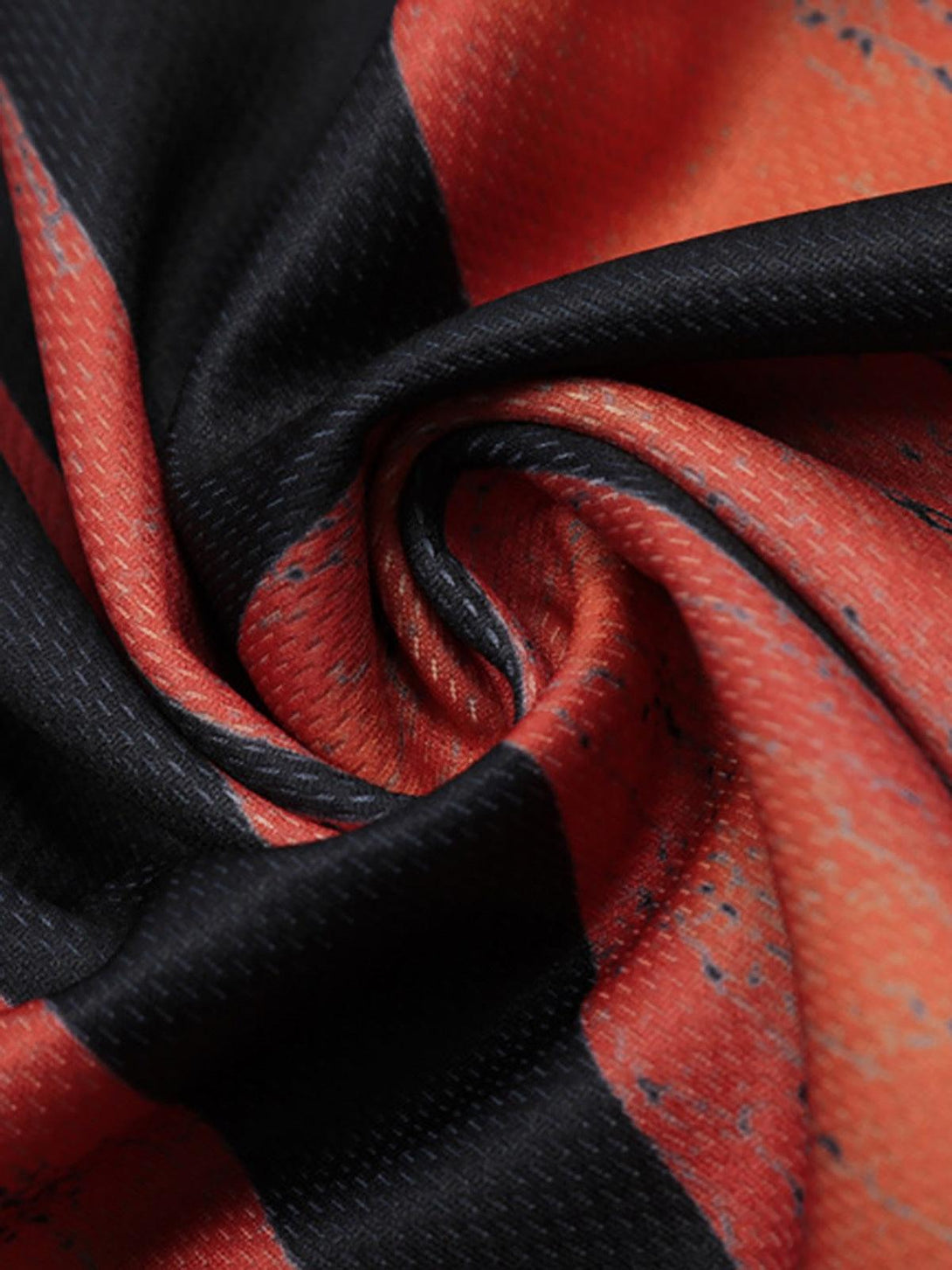 A tight crop highlighting the vibrant flame pattern on a TALISHKO crew neck T-shirt.