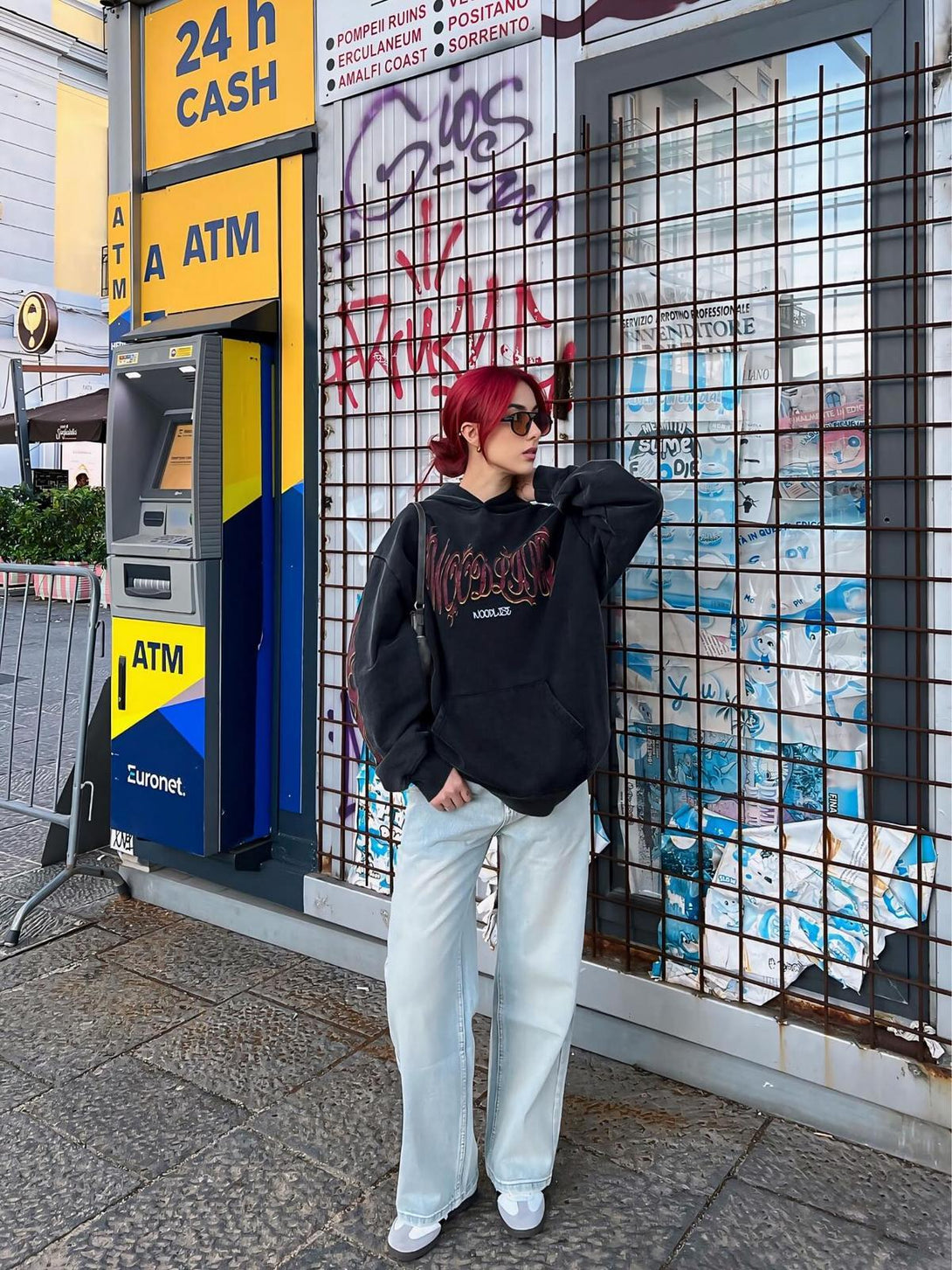 Model wearing a TALISHKO flame letter washed hoodie, paired with light jeans for a casual street vibe.