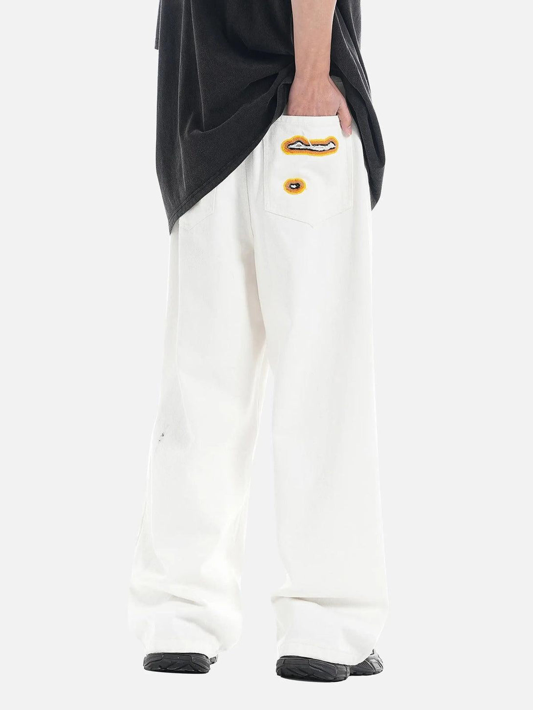 Back view of TALISHKO jeans with flame-scarred embroidery and relaxed, wide-leg fit.