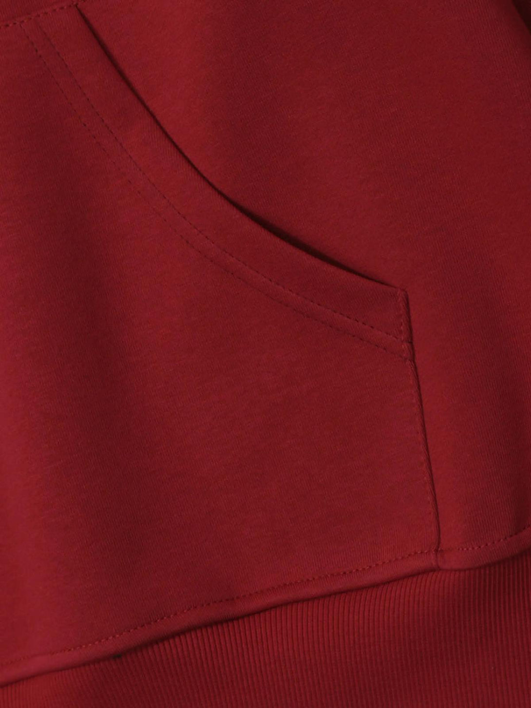 A close-up of the TALISHKO hoodie pocket, highlighting the rich red fabric and seamless stitching.