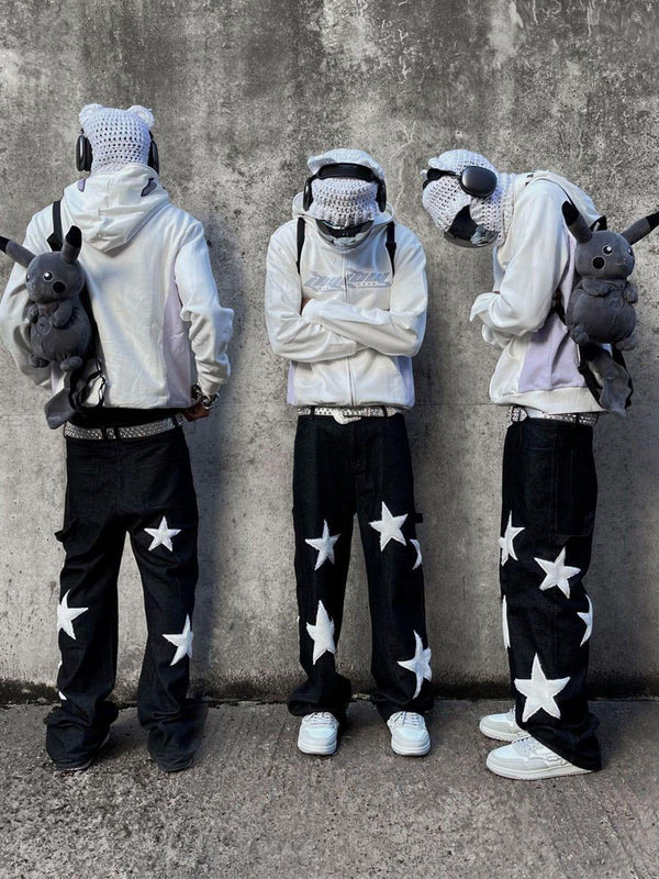 Three models wear TALISHKO's black jeans with bold white stars, styled with white hoodies.