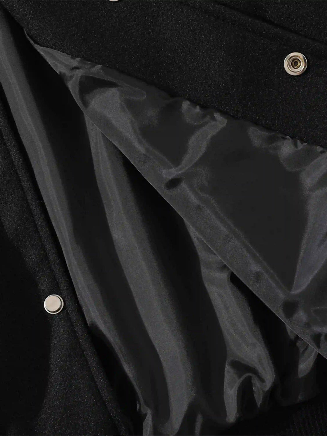 Focusing on the sleek interior lining of a TALISHKO baseball jacket, highlighting craftsmanship.