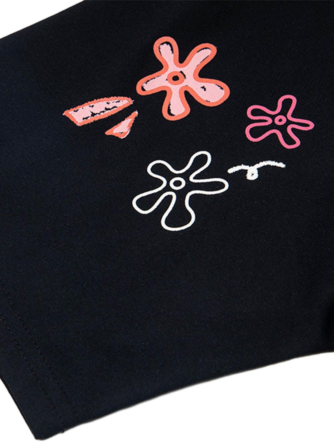 Focusing on playful floral embroidery on black TALISHKO T-shirt, highlighting vibrant design.