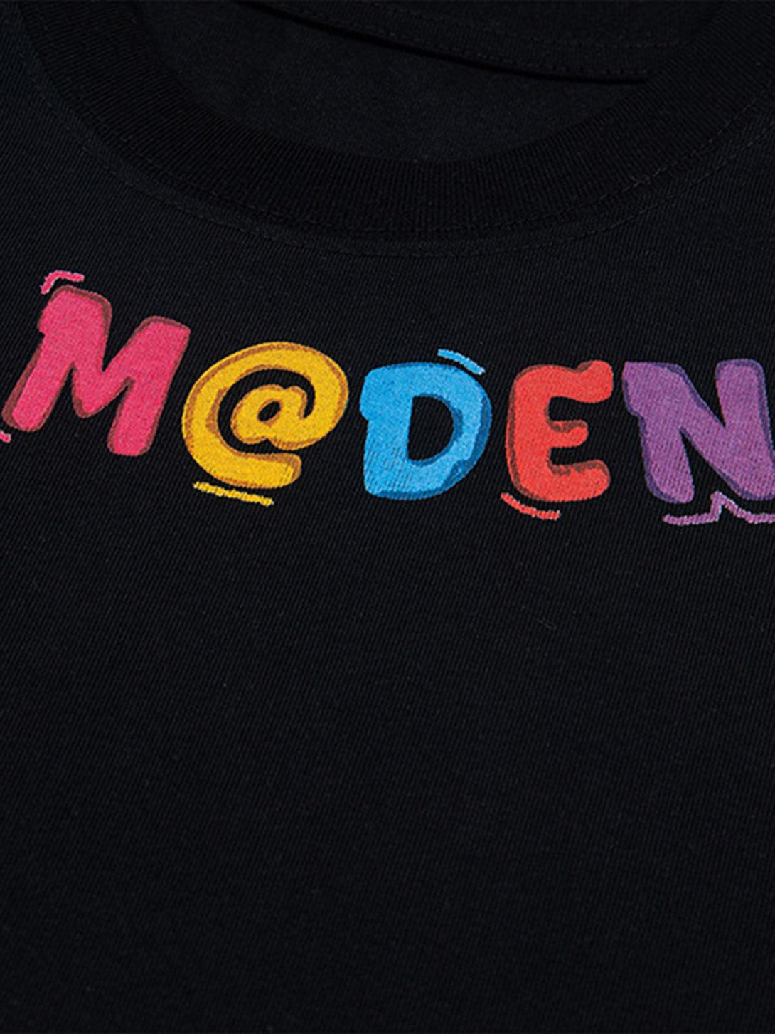 A tight crop highlighting colorful embroidery on a black TALISHKO T-shirt, showcasing playful design.