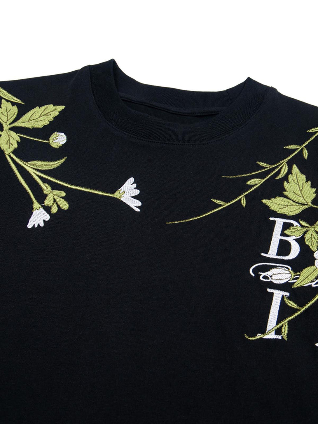 Intricate floral embroidery detail on a black oversized t-shirt by TALISHKO.