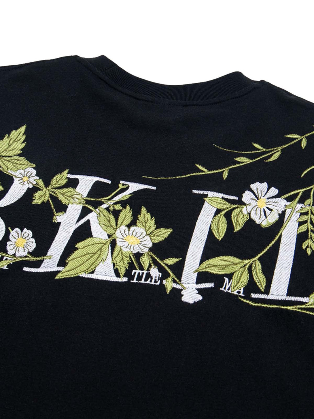 Floral embroidery detail on a black oversized t-shirt by TALISHKO, showcasing intricate design.