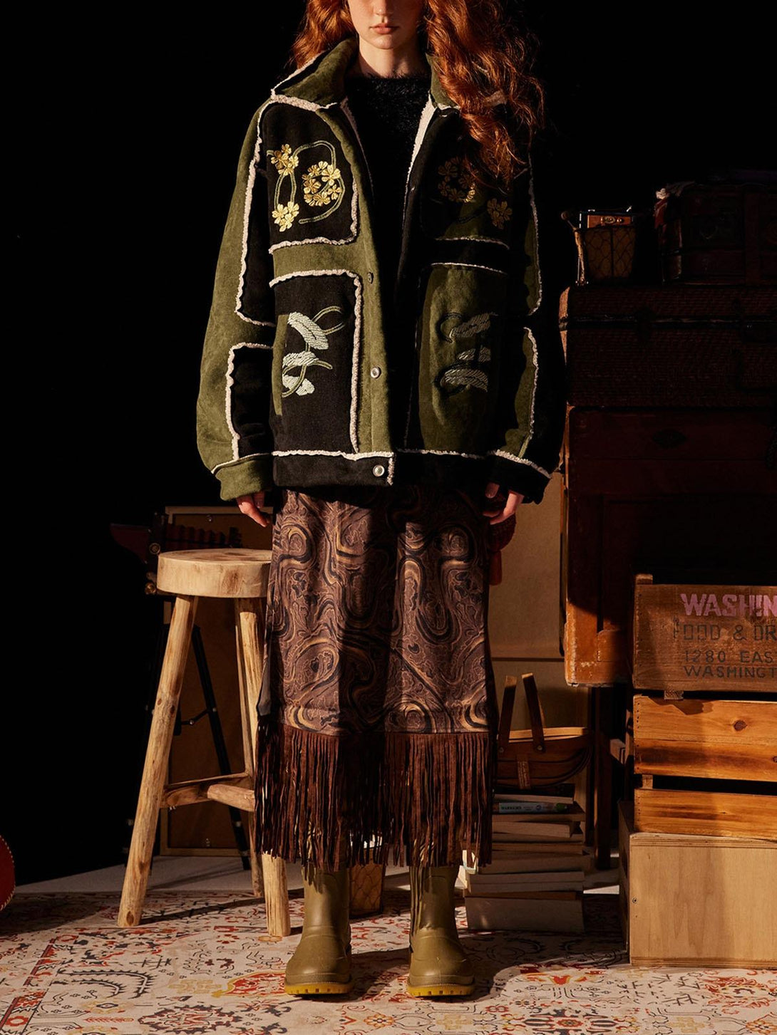 Model styled in TALISHKO's floral embroidered fleece jacket, paired with a fringe skirt.