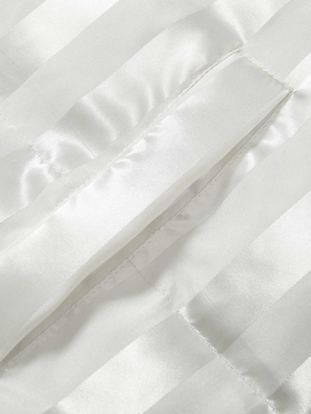 Detailed fabric and stitching of a striped cotton coat by TALISHKO, showcasing texture.