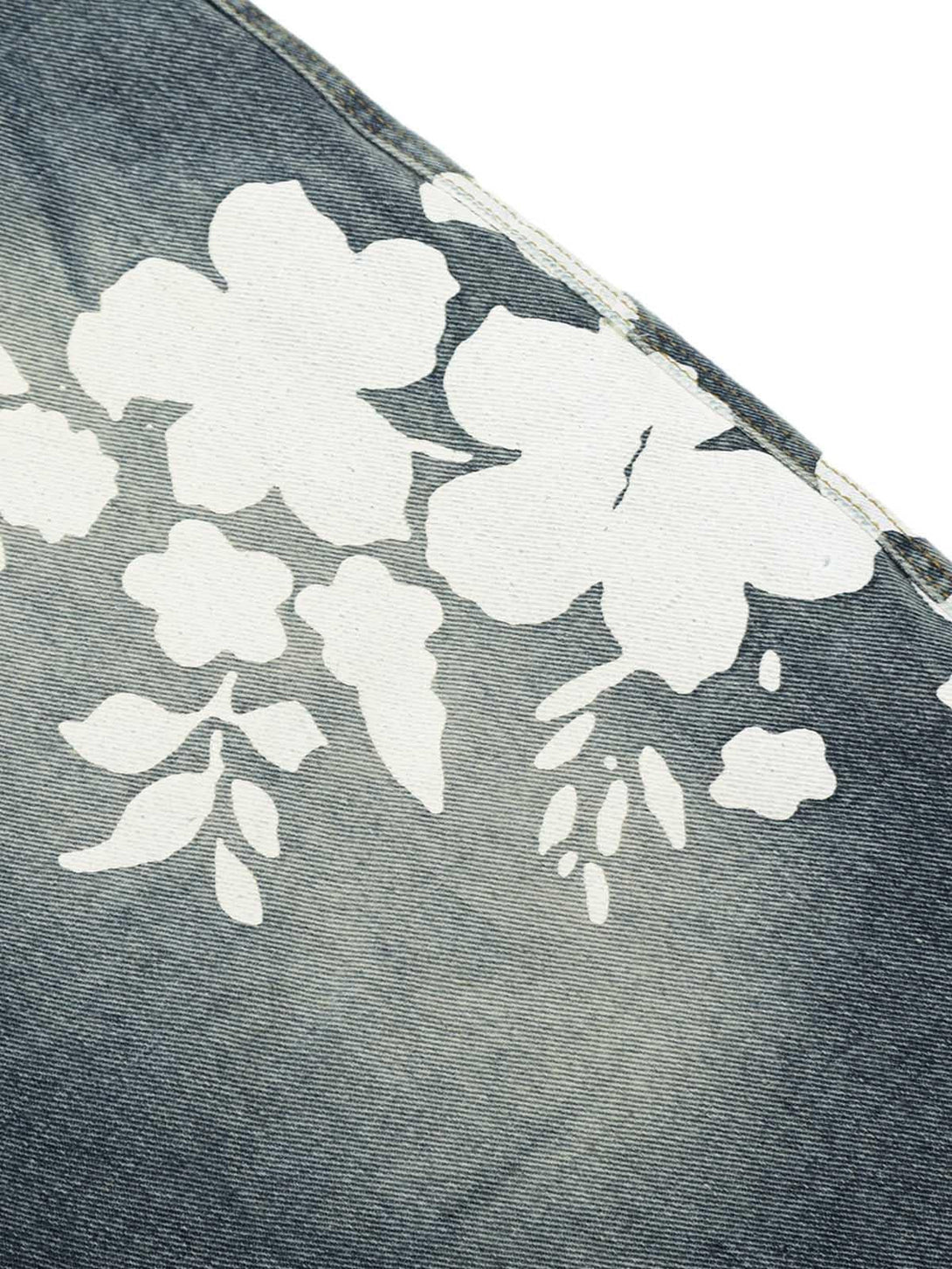 A detailed view of floral pattern on denim shorts by TALISHKO, showcasing intricate design.