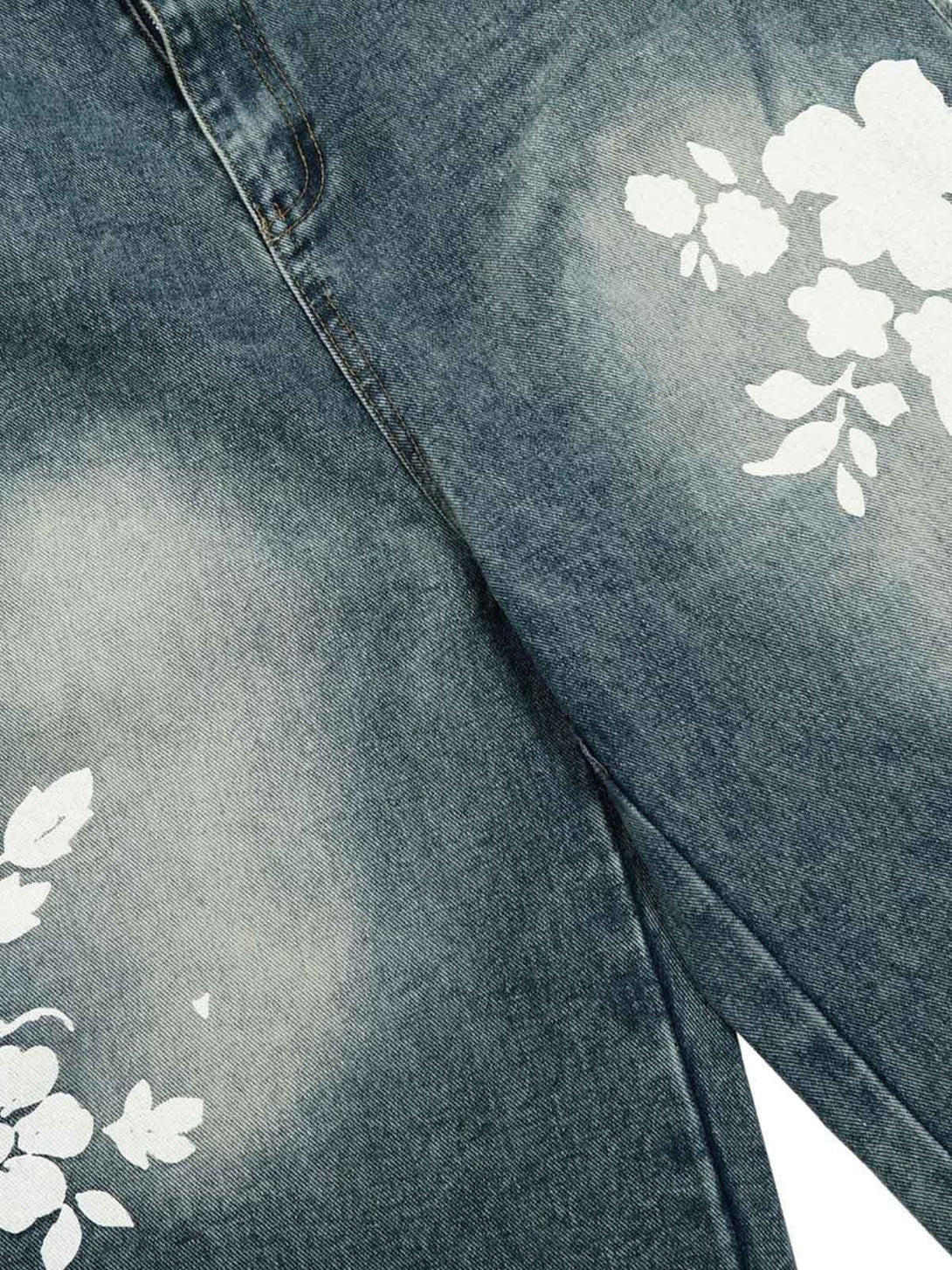 Close-up of floral print design on denim shorts by TALISHKO, highlighting unique patterns.