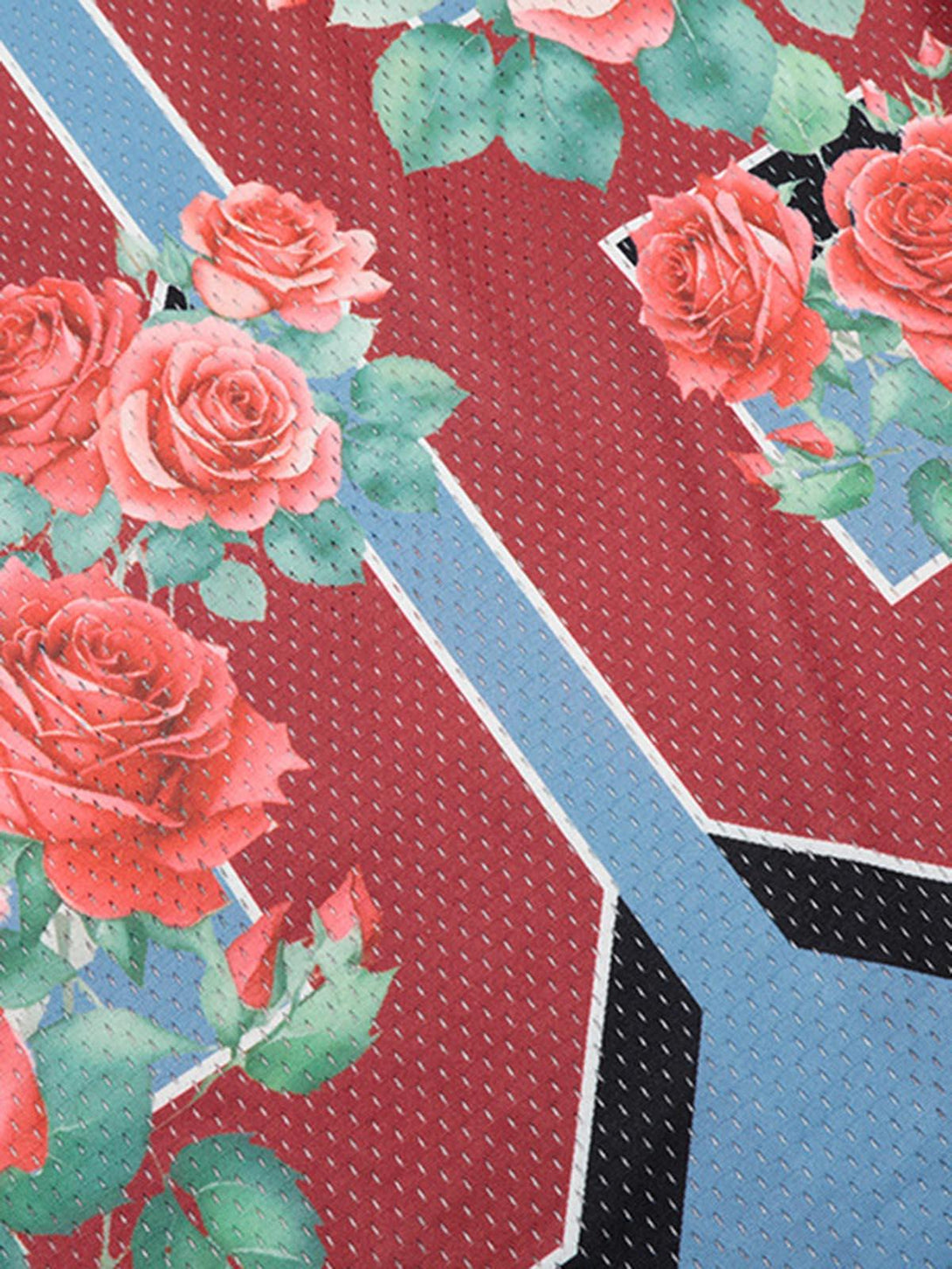 A detailed view of TALISHKO's floral print jersey fabric, highlighting vibrant rose patterns.