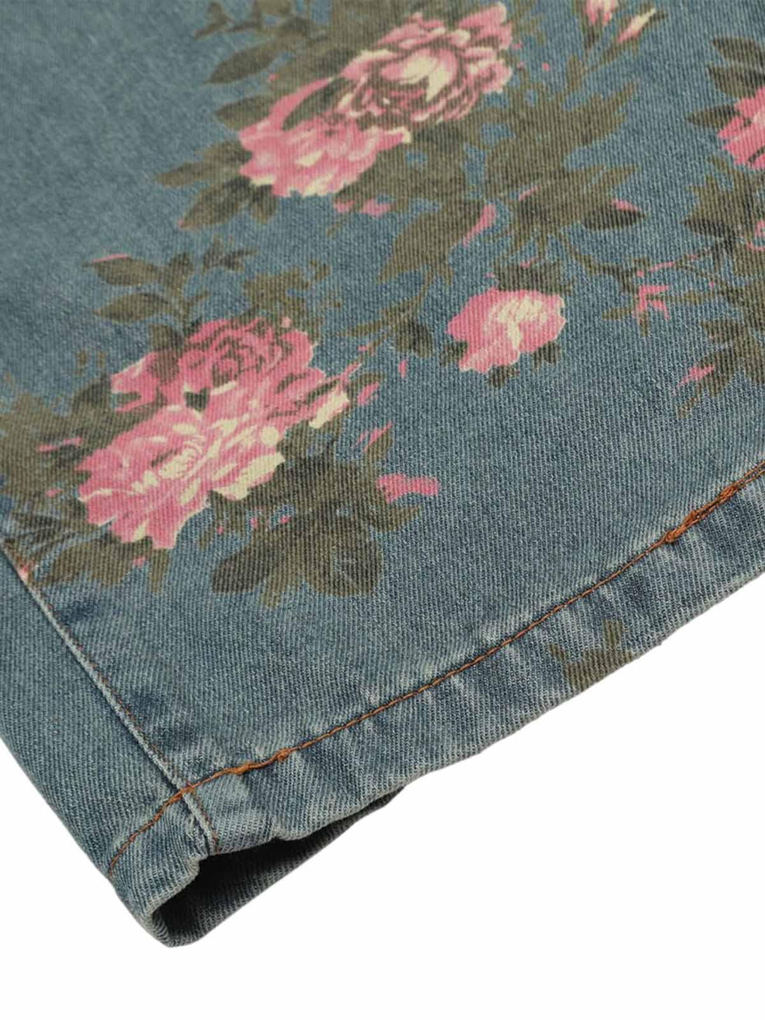 A detailed look at TALISHKO floral print jeans, highlighting pink rose patterns and stitching.