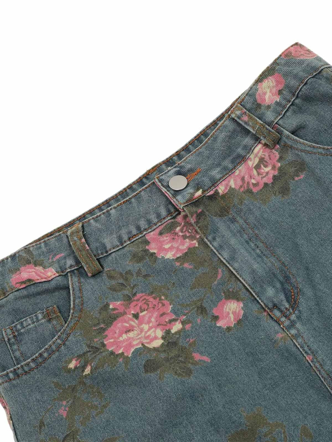 Detailed view of TALISHKO floral print jeans, highlighting intricate pink floral patterns.