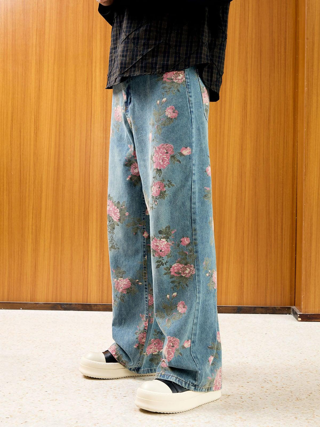 Model wearing floral print straight jeans by TALISHKO, styled with casual sneakers and a plaid shirt.