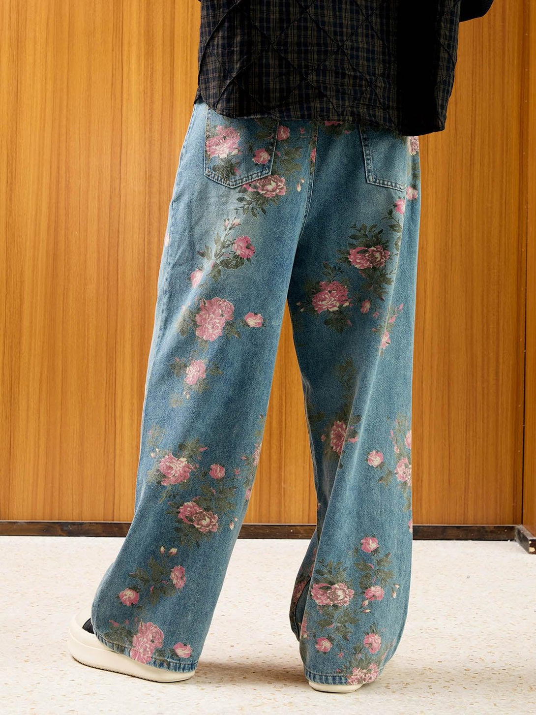 Back view of TALISHKO floral print jeans, styled with a plaid shirt for a casual flair.