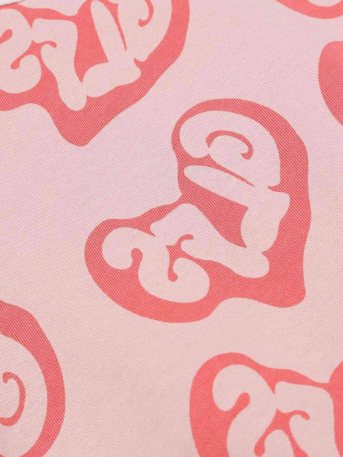 Zoomed-in texture of a pink Foam Heart Hoodie by TALISHKO, highlighting intricate graphic patterns.
