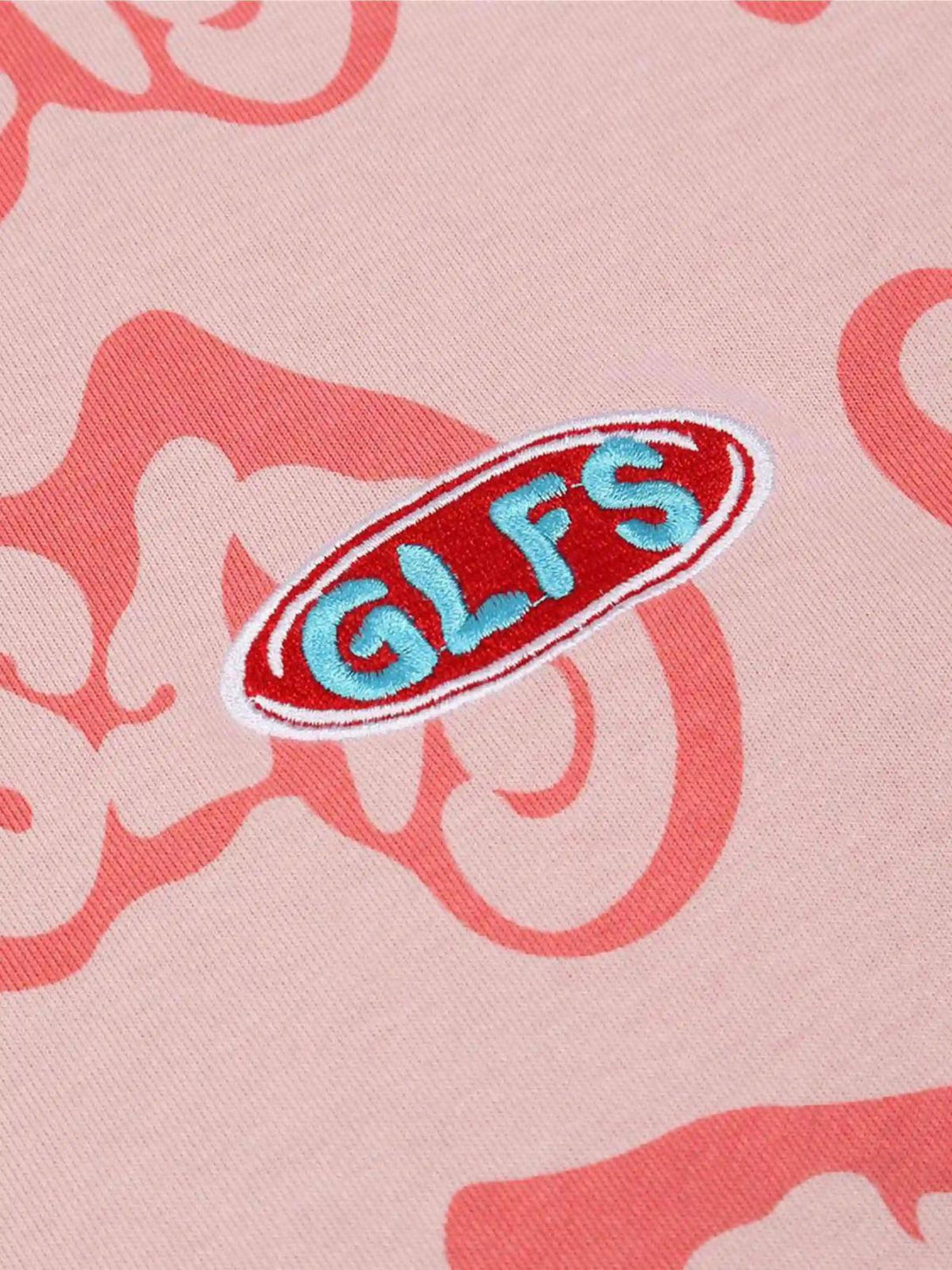 Zoomed-in detail of a pink Foam Heart Hoodie by TALISHKO, highlighting vibrant embroidered logo.