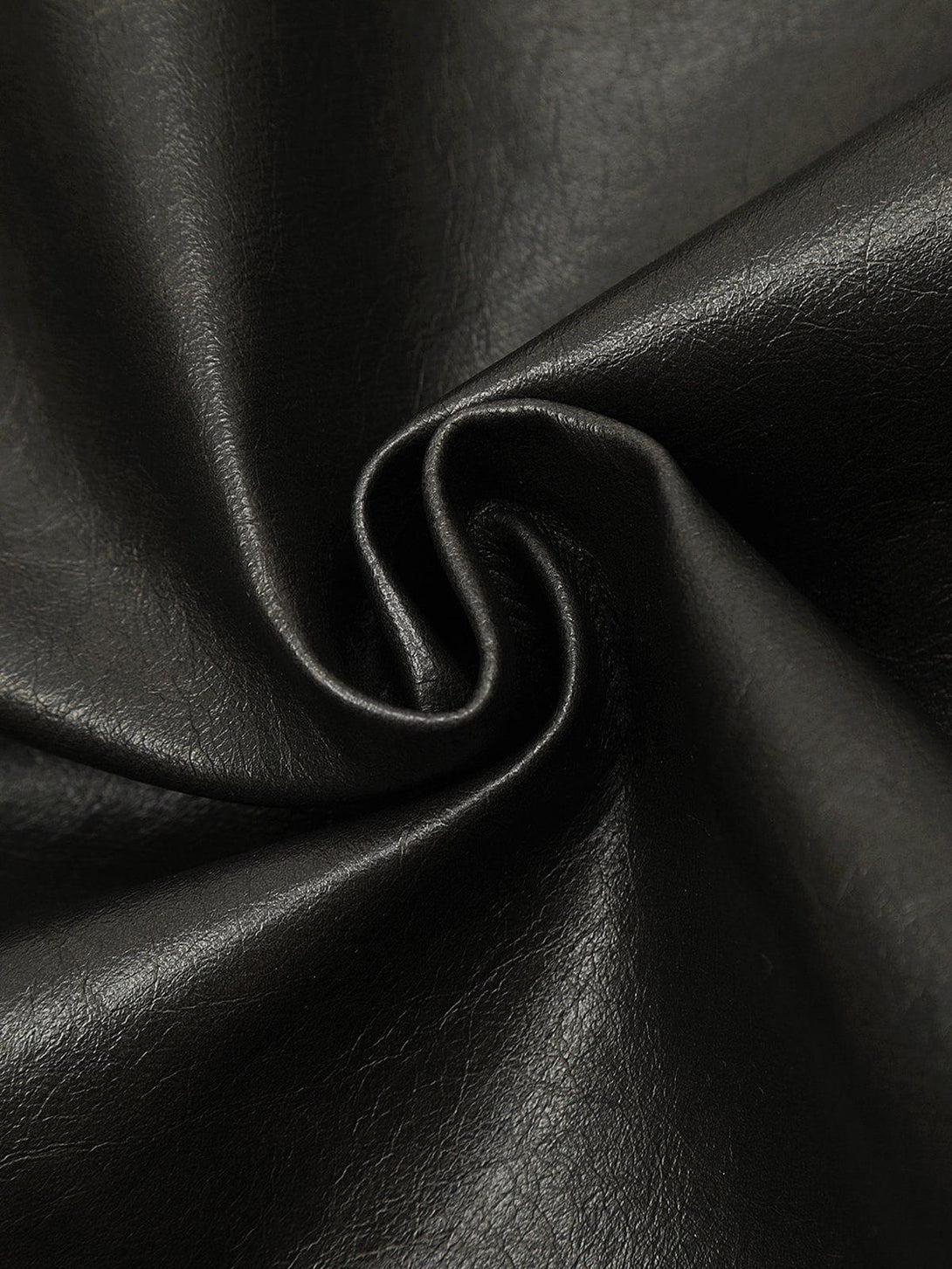 A textured view of black faux leather material by TALISHKO, highlighting its smooth finish.