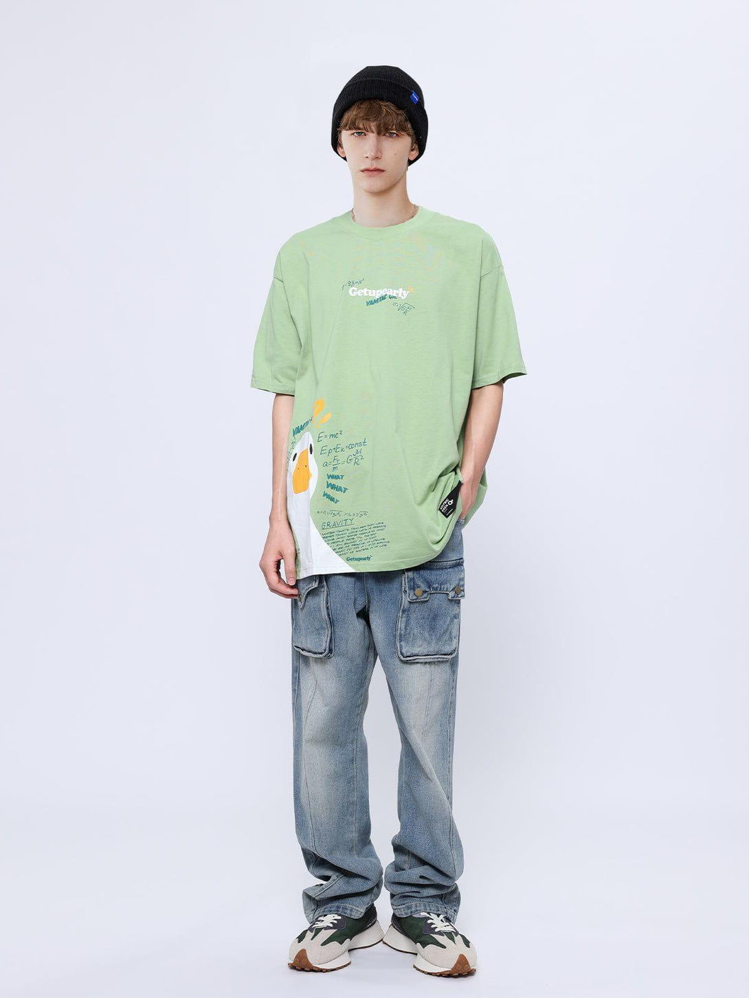 Model wearing a playful green tee with duck graphics and formulas, designed by TALISHKO.