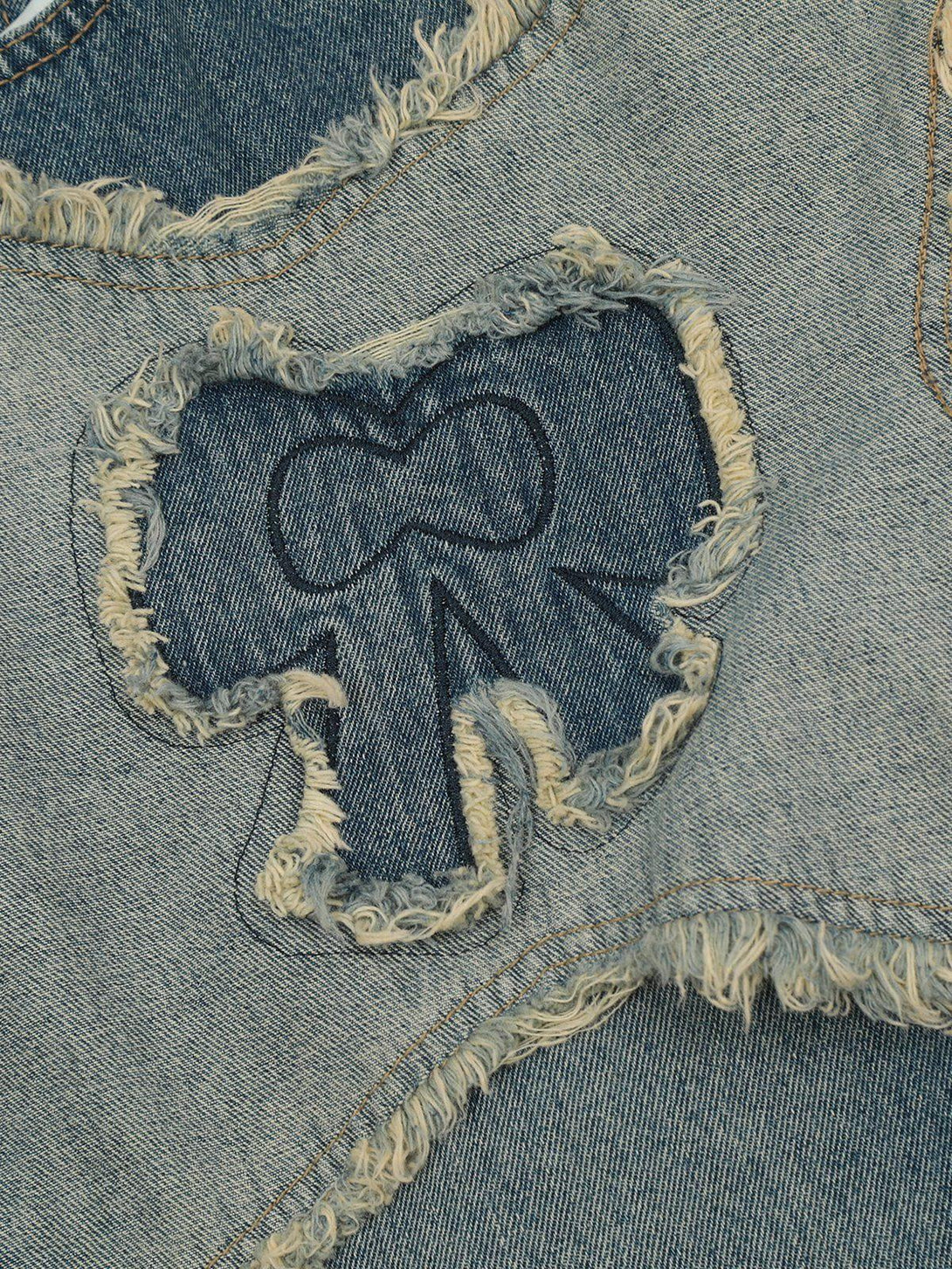 Intricate look at TALISHKO fringe bow jeans, highlighting distressed details and unique design.