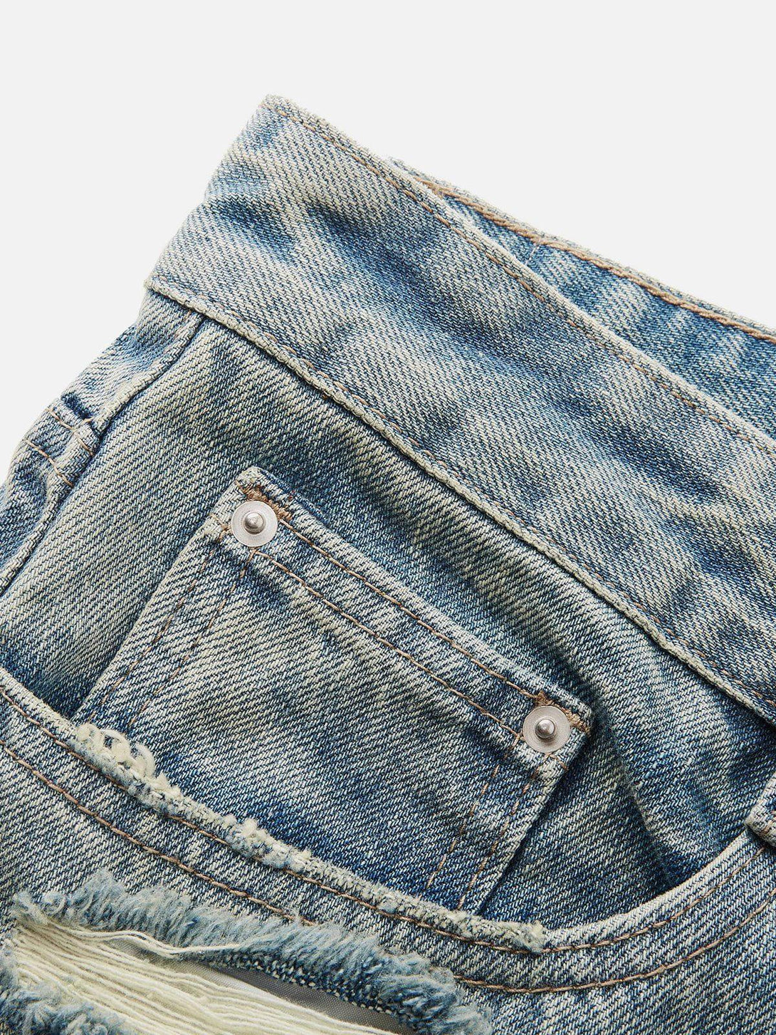 Detailed fabric and stitching of TALISHKO fringe distressed jeans, highlighting rugged denim style.