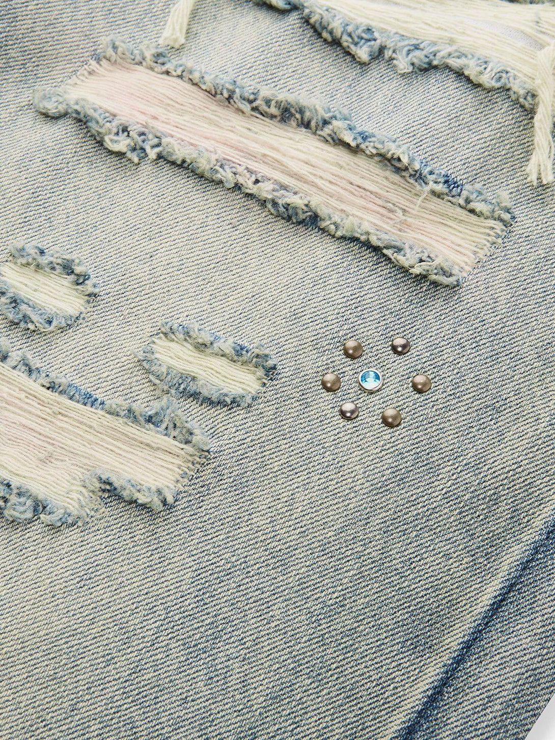 Focusing on the distressed details and embellishments of TALISHKO fringe jeans for a trendy look.