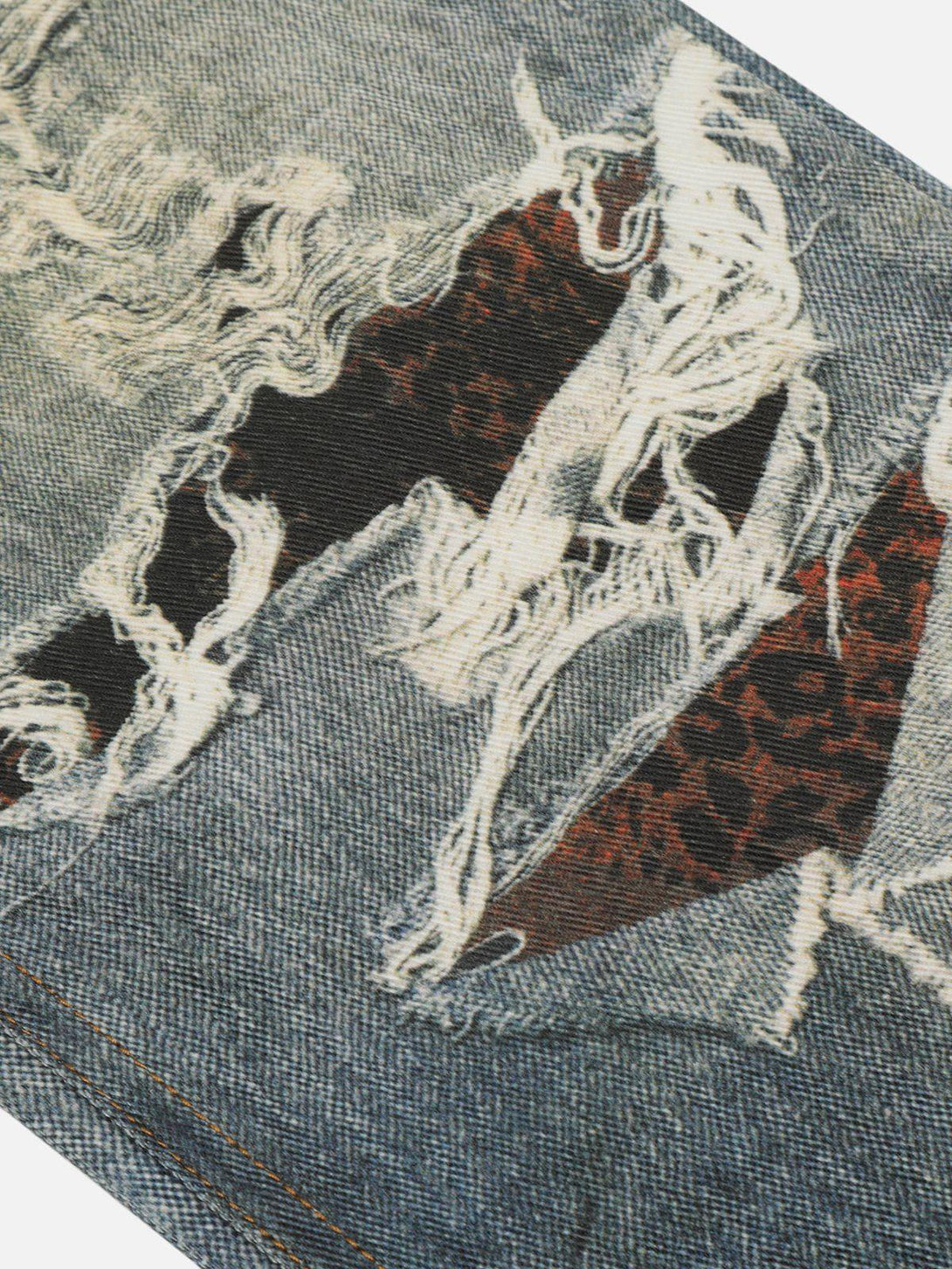 A close-up of fringe distressed print jeans by TALISHKO, highlighting intricate fabric details.