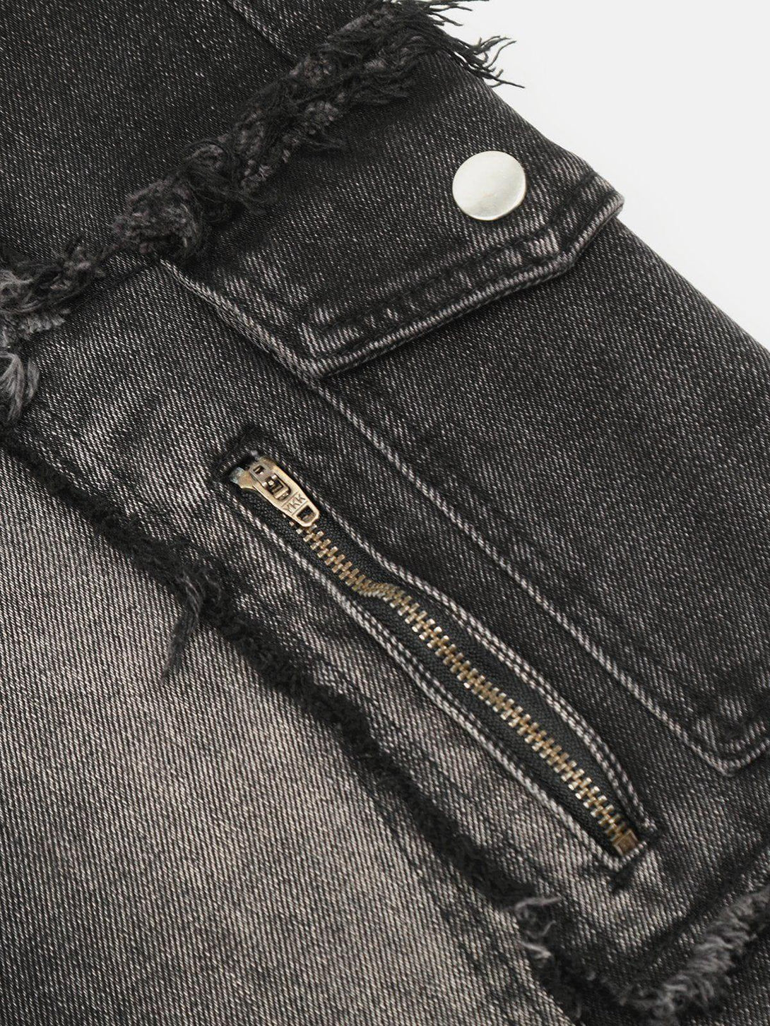 Intricate look at TALISHKO's fringe multi-pocket jeans, highlighting zipper and texture details.
