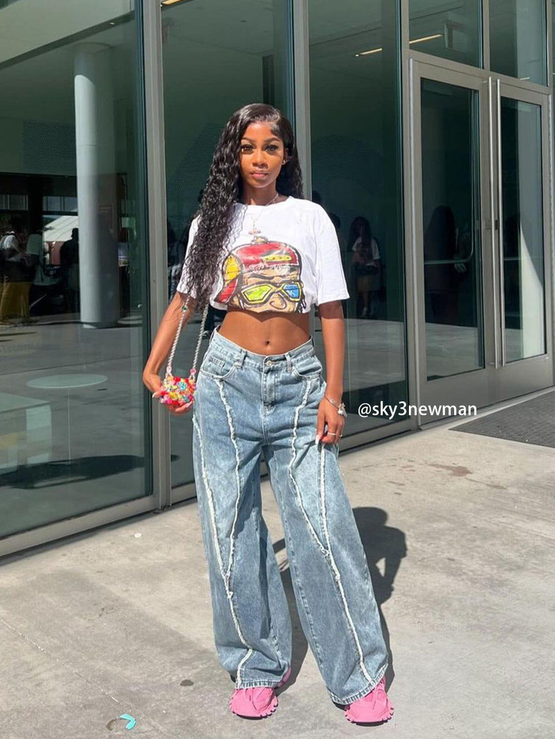 Model wearing TALISHKO's fringe patchwork loose jeans with a graphic crop top and pink shoes.