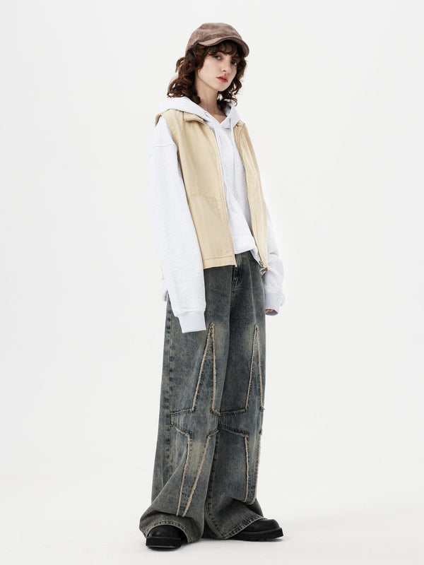 Model wearing TALISHKO oversized fringe star jeans with a casual hoodie and vest ensemble.