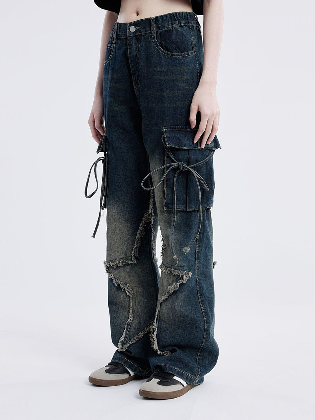 Model wearing TALISHKO jeans with fringe star design and cargo pockets, highlighting edgy style.