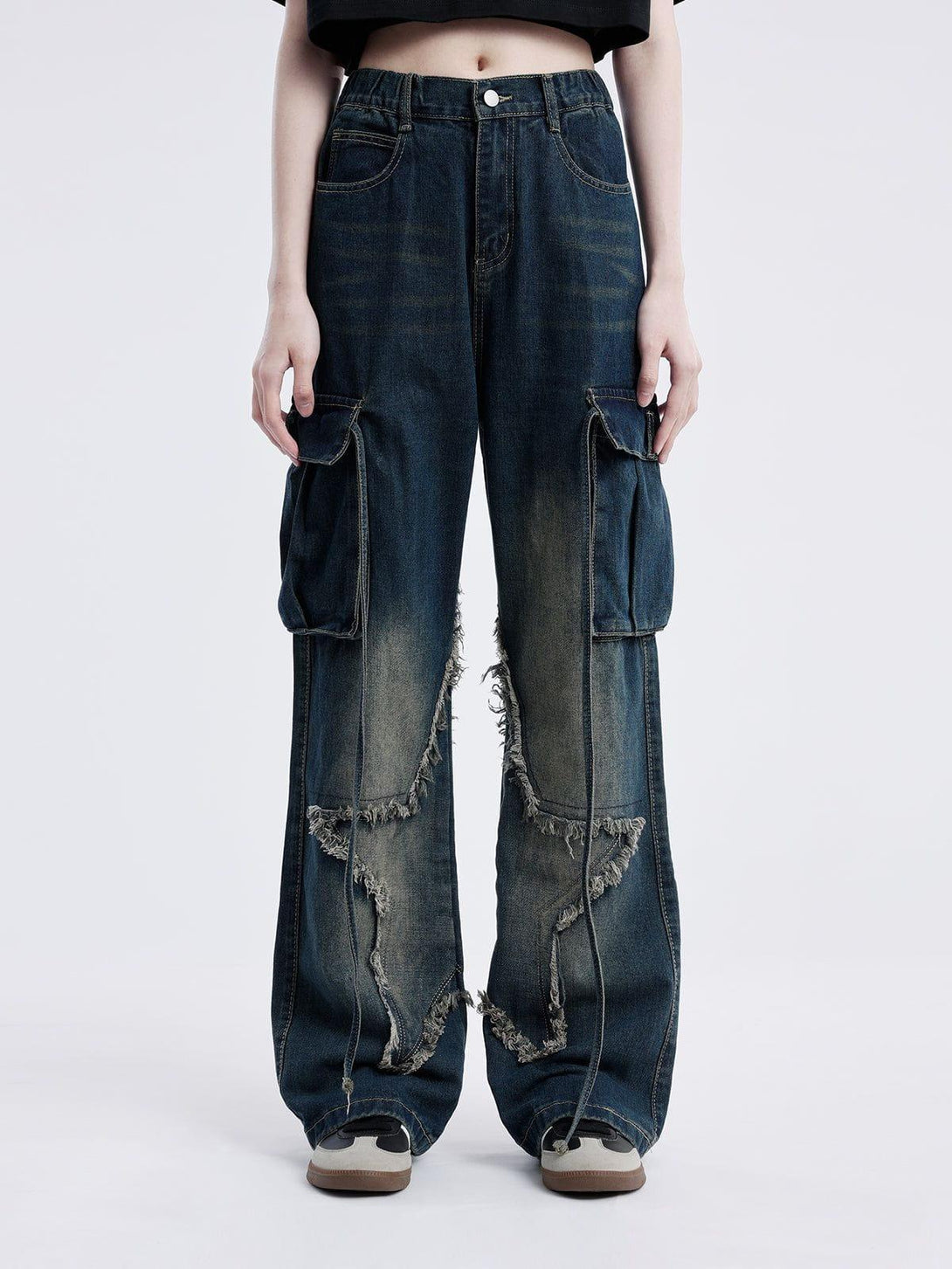 Model wearing TALISHKO fringe star washed jeans, highlighting trendy cargo pockets and frayed edges.