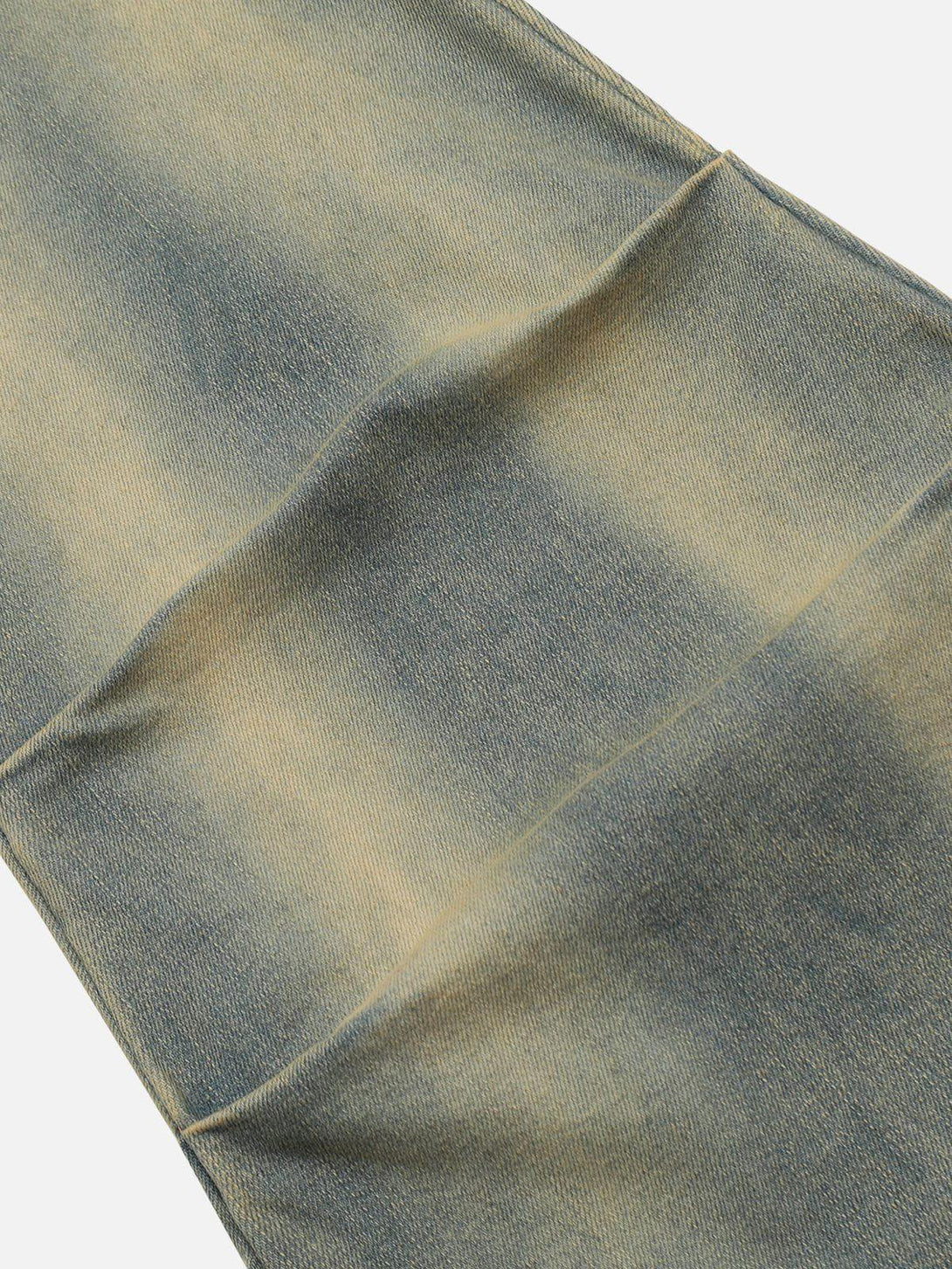 A detailed view of TALISHKO's fringe waist jeans texture, showcasing their unique faded wash.