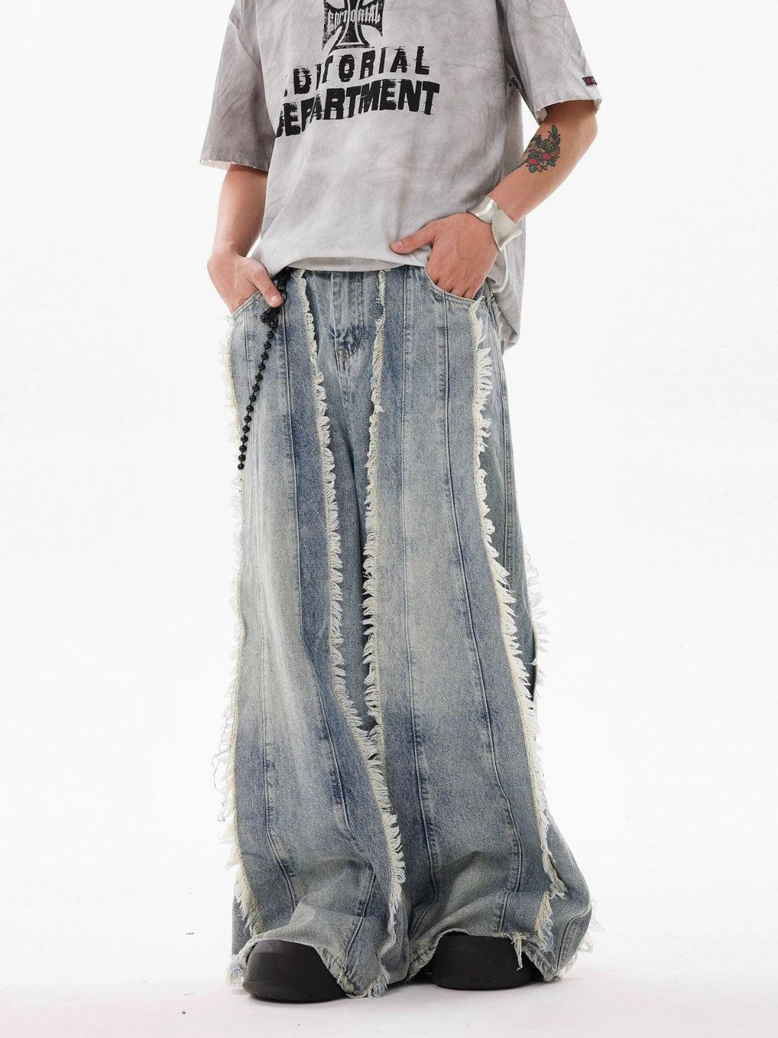 TALISHKO denim jeans with fringe details, worn with a graphic tee for a relaxed urban style.