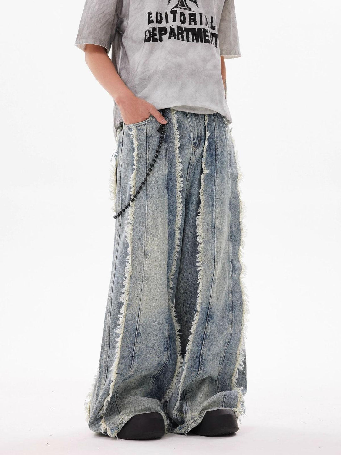 Fringe washed jeans by TALISHKO, worn with a graphic tee, highlighting a relaxed street style.