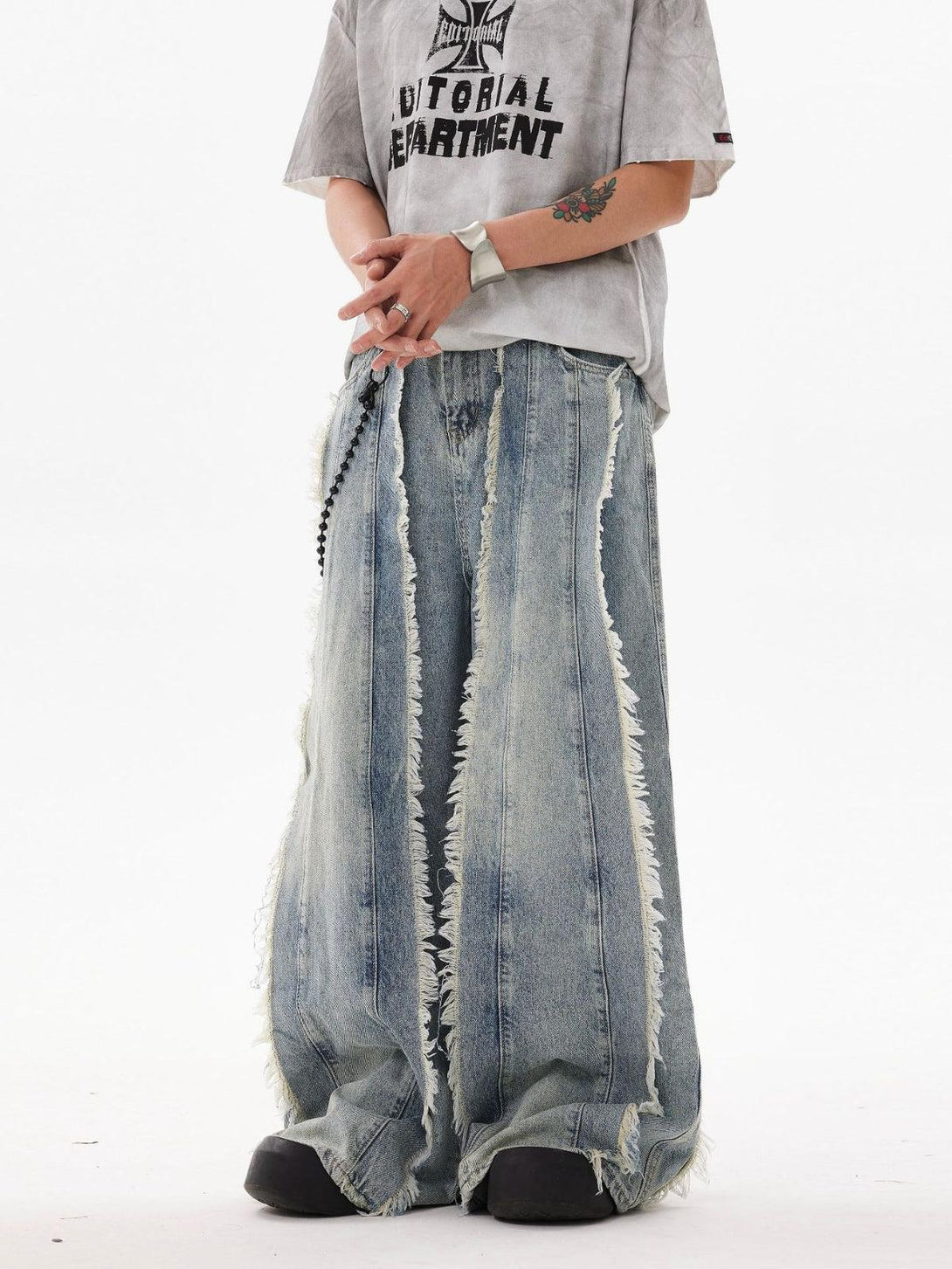 Model wearing TALISHKO's fringe washed jeans, styled with a graphic tee for a trendy look.