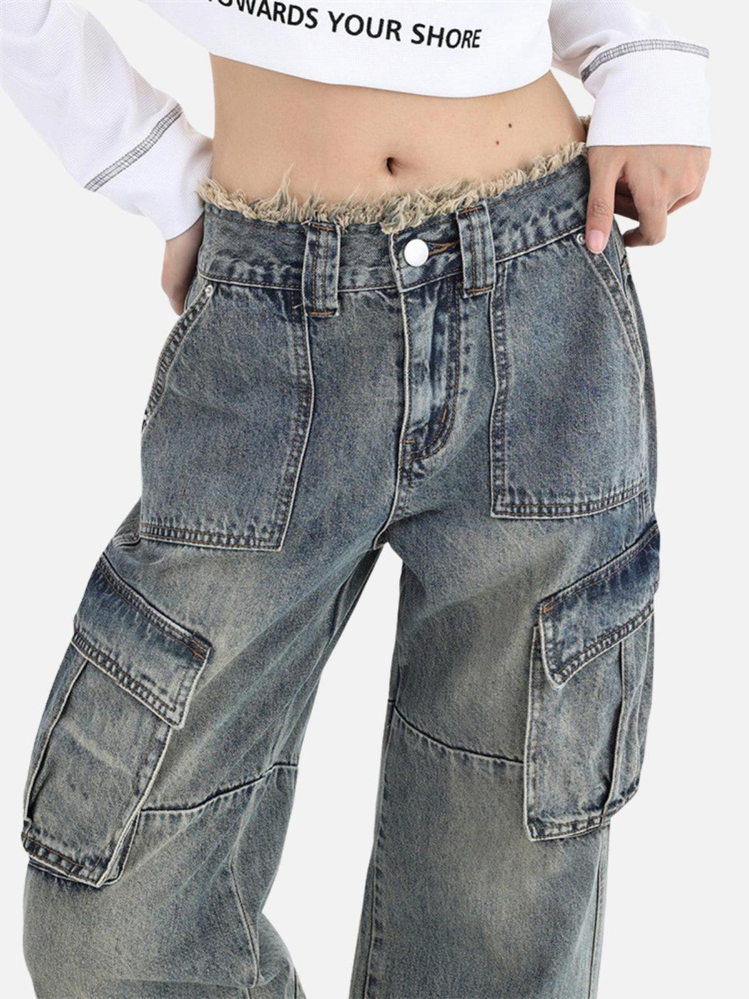Focusing on the fringe waist detail of TALISHKO's washed multi-pocket jeans in a casual style.