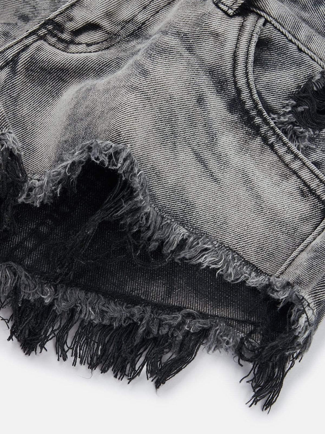 Intricate look at gray fringe detailing on washed shorts by TALISHKO, exuding a casual vibe.