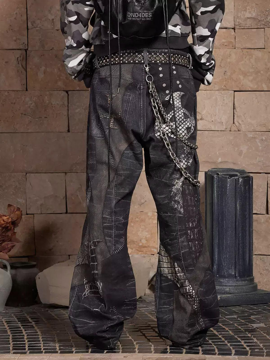 Back view of leather flare jeans with chain detail and studded belt by TALISHKO, showcasing edgy style.