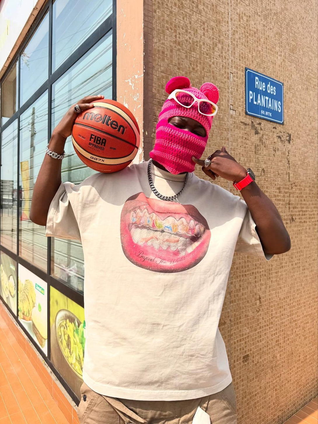 Person wearing a TALISHKO graphic tee with a unique teeth design, posing with a basketball.