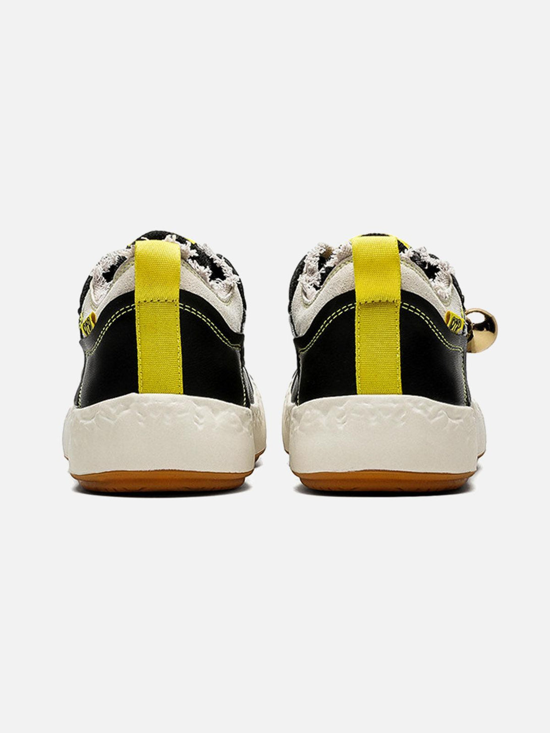 Rear view of TALISHKO sneakers, showcasing vibrant yellow pull tabs and textured soles.