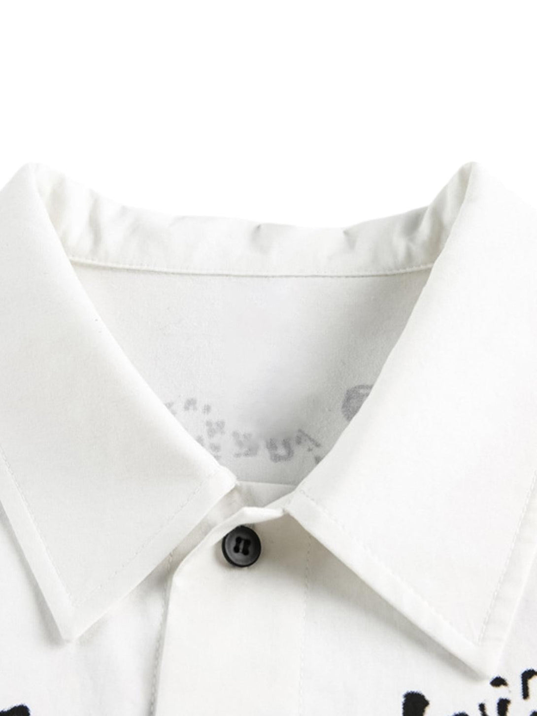 Detailed view of a white shirt collar with fun graffiti prints by TALISHKO, highlighting style.